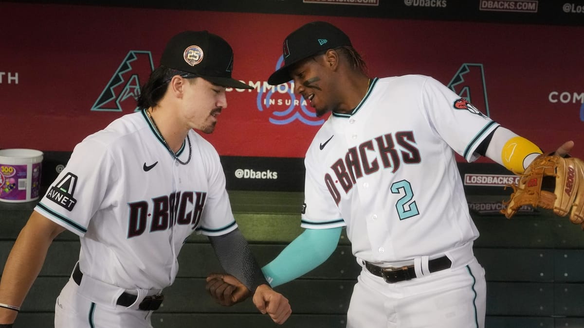 Corbin Carroll (7) and Geraldo Perdomo (2) shake hands in the Diamondbacks dugout at Chase Field.
