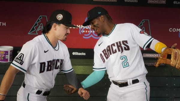 Corbin Carroll (7) and Geraldo Perdomo (2) shake hands in the Diamondbacks dugout at Chase Field.